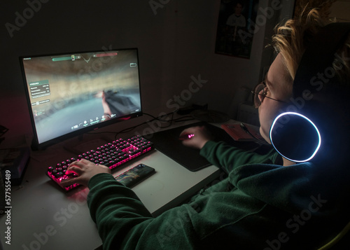osoba grająca na komputerze w nocy.