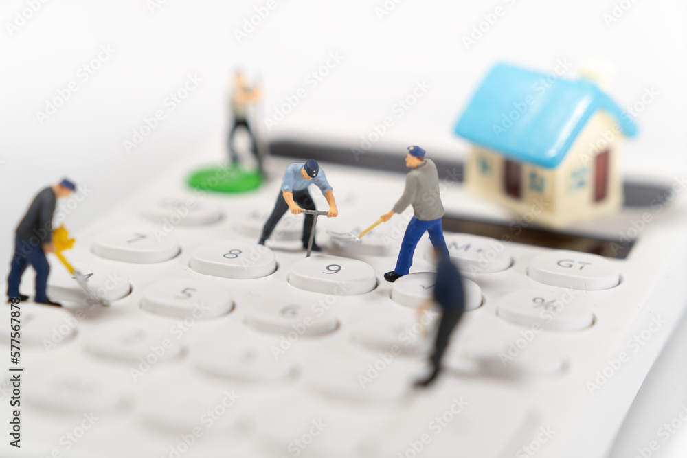 Tiny houses on stacked calculators used as real estate and business finance concept Tiny houses on stacked calculators used as real estate and business finance concept