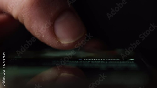 Macro shot of a finger doom scrolling social media or browsing internet. Front view with reflection on glass