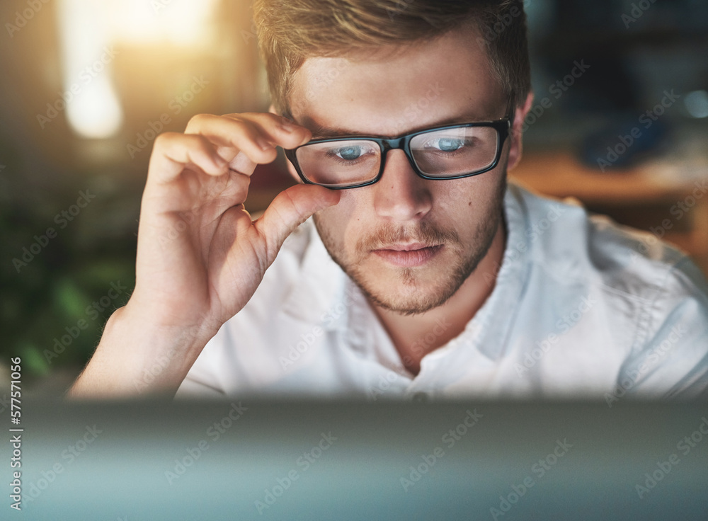 Am I seeing this right. Shot of a young designer adjusting his glasses as he looks at his computer screen. Am I seeing this right. Shot of a young designer adjusting his glasses as he looks at his computer screen.