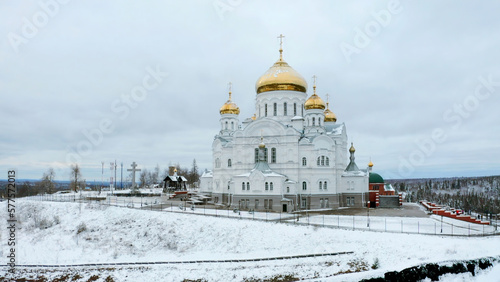 Winter view. Clip. Snow strewn on the road and a large white Orthodox church with golden domes.