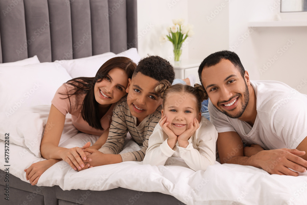Happy international family lying on bed at home Happy international family lying on bed at home