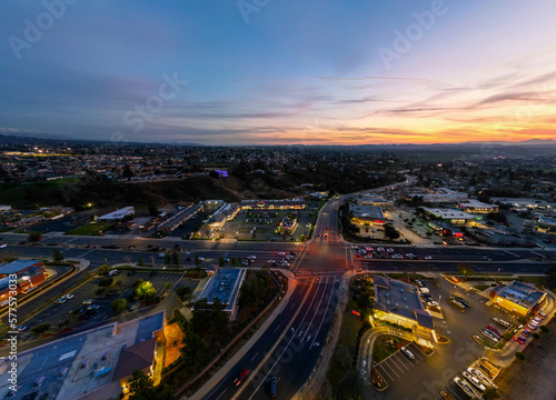 An Aerial View of the Sun Going Down over Yucaipa, California, with a Super market Shopping Complex and Traffic Below