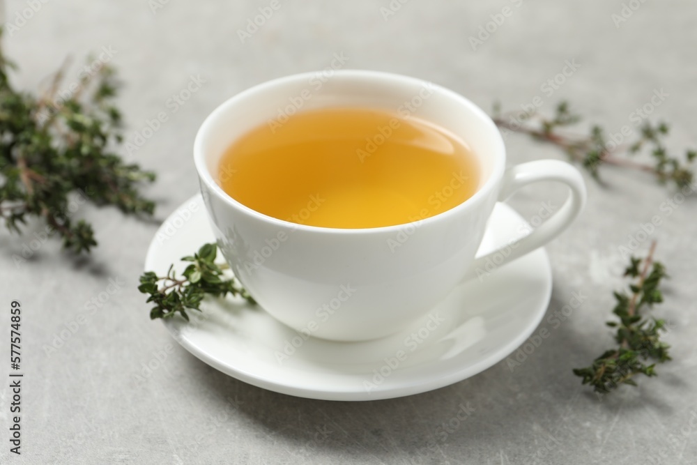Aromatic herbal tea with thyme on light grey table, closeup Aromatic herbal tea with thyme on light grey table, closeup