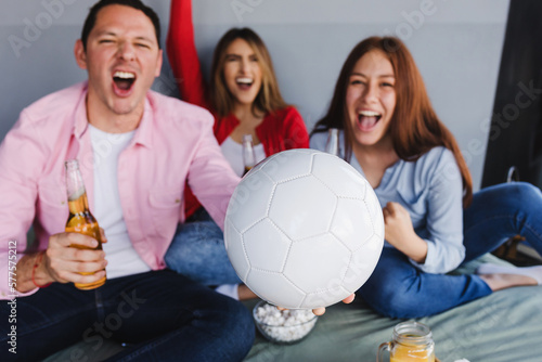Hispanic friends watching soccer world cup on television at home in Mexico Latin America