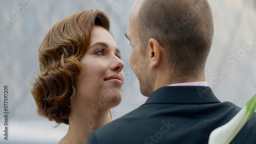 Portrait of an attractive couple, woman with red curly hair and a man in suit. Action. Loving man and woman embracing, smiling lady.
