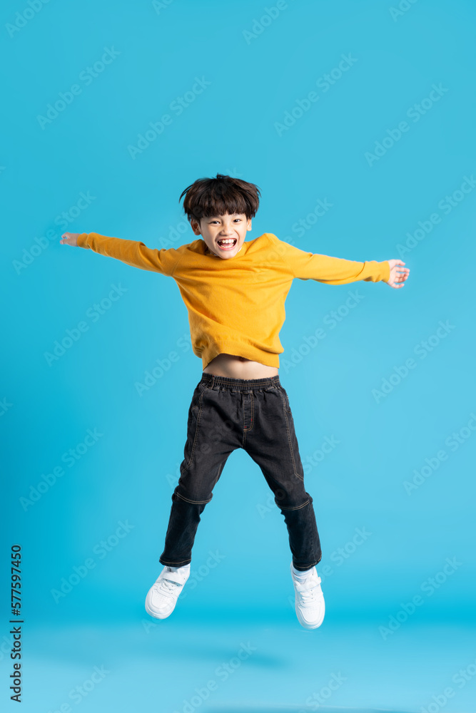 full body image of asian boy posing on blue background