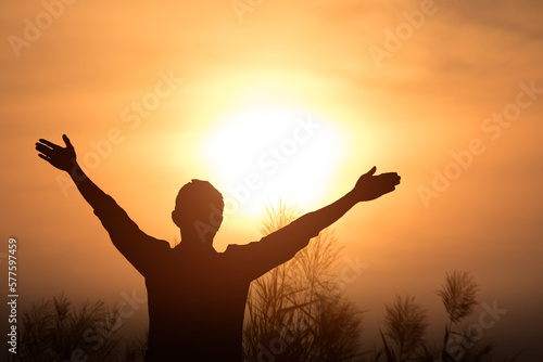 Man with arms raised in thanksgiving