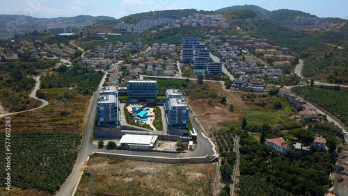 Aerial view of the budget hotel with the outdoors swimming pool. Clip. Southern green city with many trees.