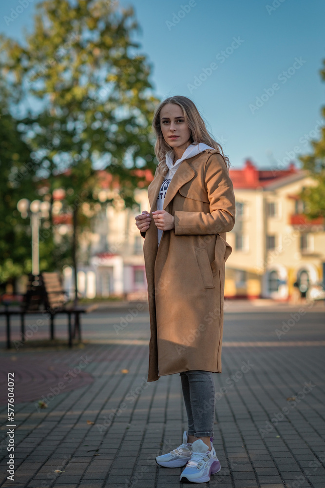 Fototapeta premium Portrait of a young beautiful fair-haired girl on a summer city street.