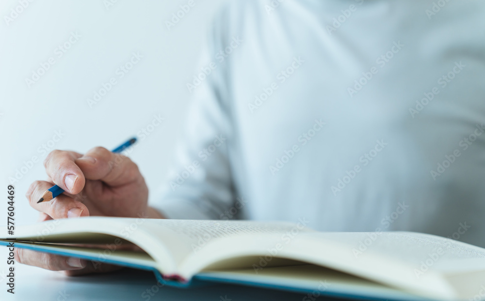 Adult writing and reading book. Student studying or learning with textbook at home. Success idea concept of education knowledge development and cognition learning .Business and education concept Adult writing and reading book. Student studying or learning with textbook at home. Success idea concept of education knowledge development and cognition learning .Business and education concept