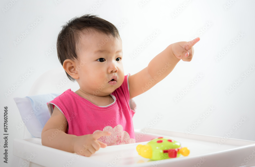 Cute Baby Boy Sitting In High Chair And Playing With His Toy Cute Baby Boy Sitting In High Chair And Playing With His Toy