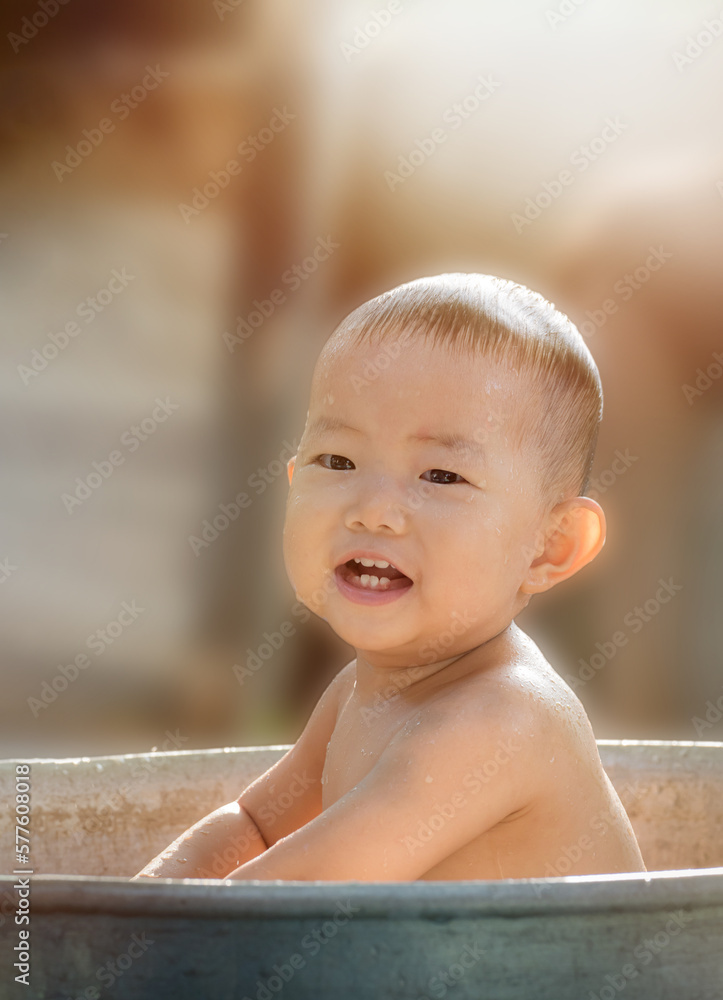 Cute asian child bathing in the garden,Cute baby boy bath outdoors and playing in a bath Cute asian child bathing in the garden,Cute baby boy bath outdoors and playing in a bath