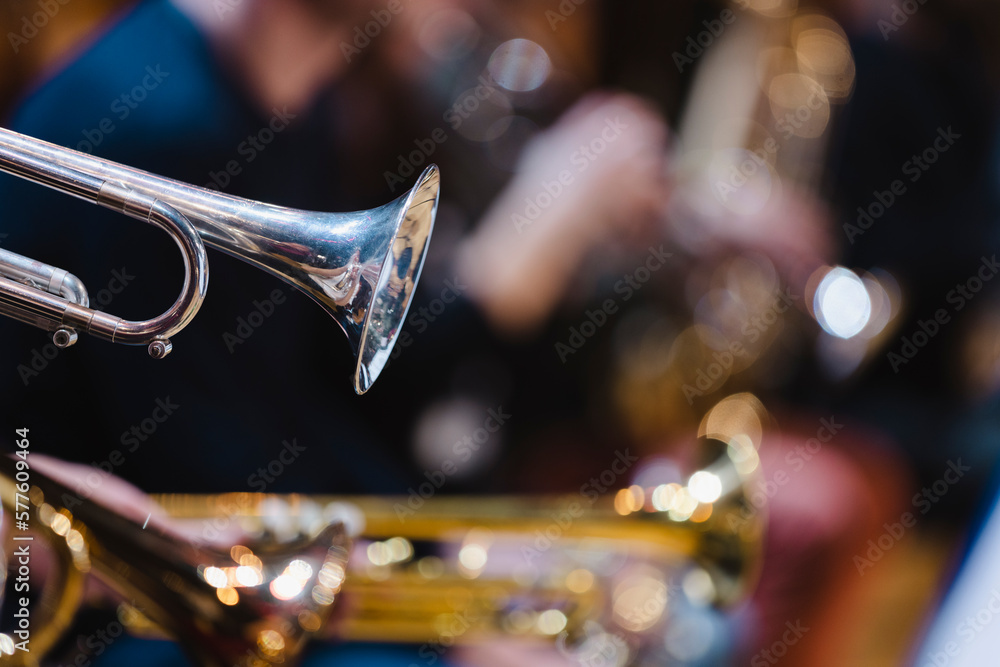 Naklejka premium A musician playing a trumpet in a trumpet section of an orchestra during rehearsal