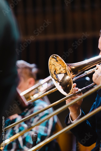 A musician playing a trombone during a casual wind ensemble rehearsal just before the concert