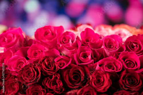 Women   s day concept. Bouquet of red roses on shining table and blue bokeh  background.