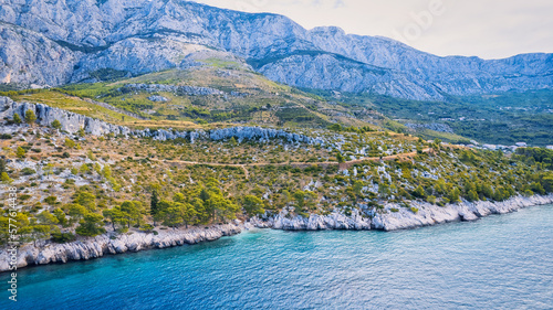 Marvel at the stunning aerial perspective of Croatia's Makarska Riviera, displaying a rocky beach and the captivating turquoise water. © Sebastian