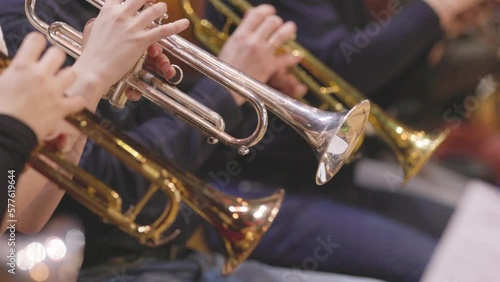 A trumpet section of an orchestra playing during a rehearsal