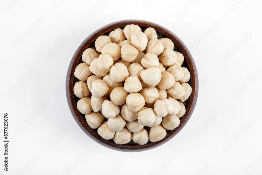 Bowl full of peeled hazelnuts on white background,top view Bowl full of peeled hazelnuts on white background,top view