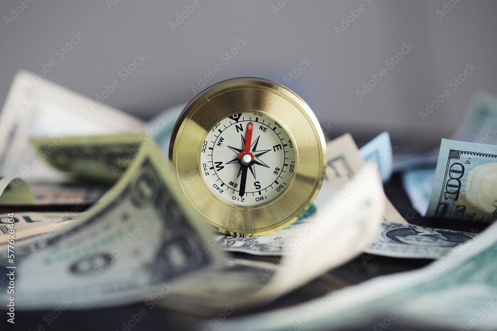 Money bill with golden Compass. Bullets and cartridge cases as a military concept. Close up US Currency and compass. business, financial idea, concept, symbol of crisis, inflation Money bill with golden Compass. Bullets and cartridge cases as a military concept. Close up US Currency and compass. business, financial idea, concept, symbol of crisis, inflation