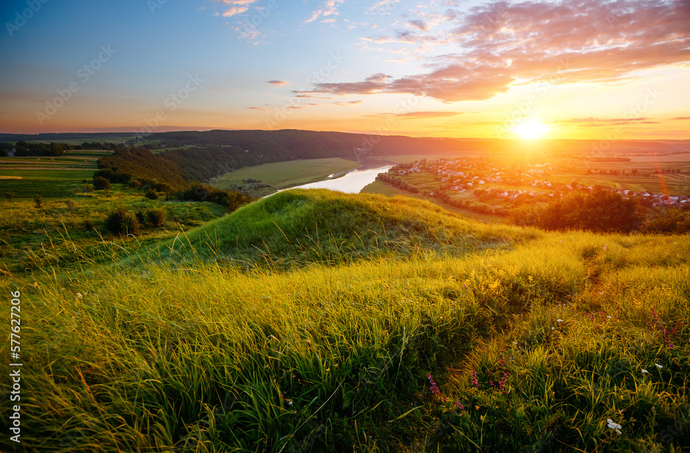 Colorful sunset and hilly meadow in golden evening light near Dniester river. Ukraine, Europe.