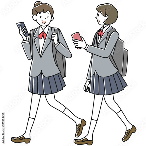 スマホを手に談笑しながら歩く2人の女子高生