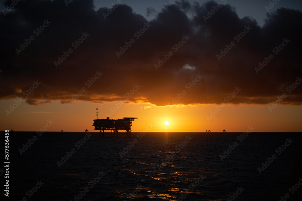 Offshore Wind Farm electrical distribution station in the sea at sunrise.