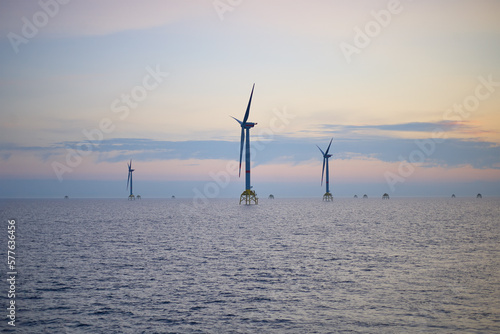 Electricity production by offshore wind turbine farm in the sea. Clean wind energy production in the sea.