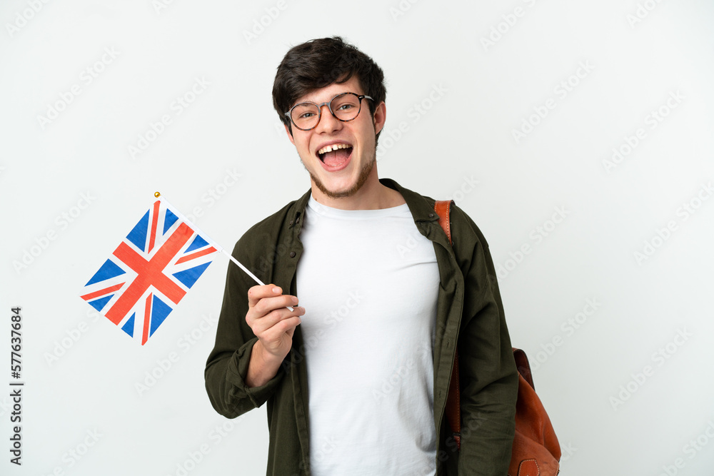 Young Russian man holding an United Kingdom flag isolated on white background with surprise facial expression - obrazy, fototapety, plakaty 
