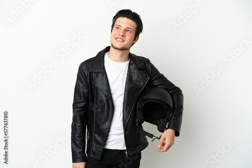 Russian man with a motorcycle helmet isolated on white background thinking an idea while looking up