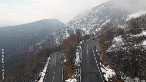Zambla pass is a mountain pass in  Orobie Pre-Alps Selvino,  province of Bergamo, which connects the Serina and Parina valleys, Curved mountain road with hairpin bends and cars in a winter snowy  photo