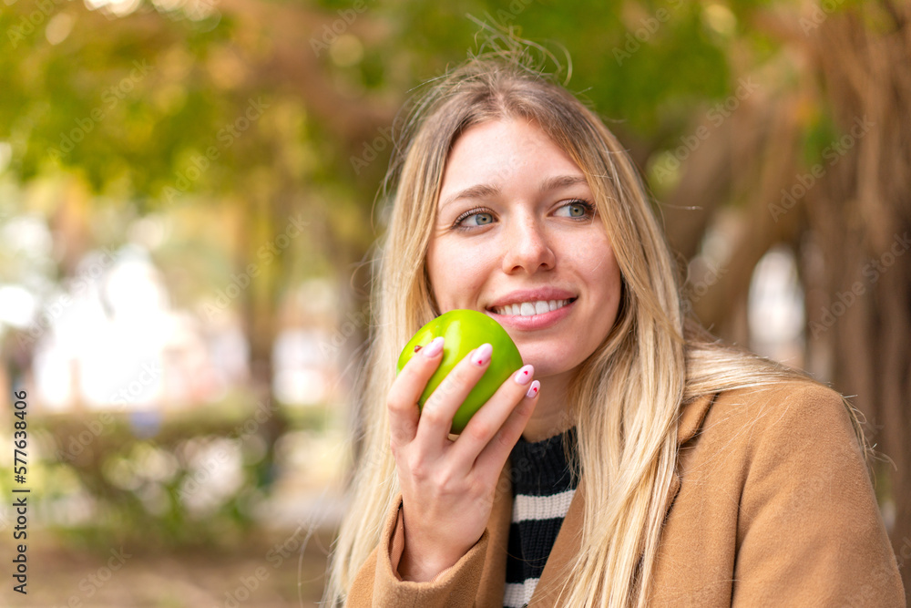 Young pretty blonde woman with an apple at outdoors Young pretty blonde woman with an apple at outdoors