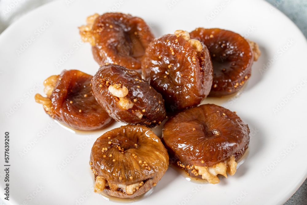 Fig dessert with sherbet on gray background. Walnut Filled Fig Dessert. Local name hatay incir tatlısı. Close up Fig dessert with sherbet on gray background. Walnut Filled Fig Dessert. Local name hatay incir tatlısı. Close up