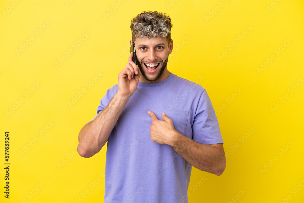Young caucasian man using mobile phone isolated on yellow background with surprise facial expression Young caucasian man using mobile phone isolated on yellow background with surprise facial expression