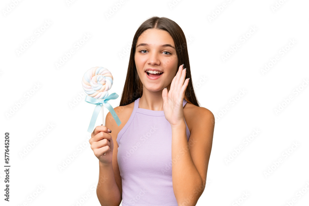Teenager caucasian girl holding a lollipop over isolated background shouting with mouth wide open Teenager caucasian girl holding a lollipop over isolated background shouting with mouth wide open