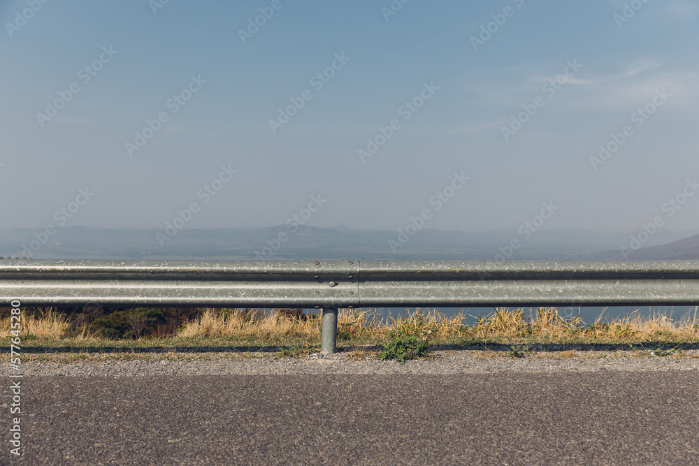 The guard rail, barrier on wayside with cloudy and hill. the straight line from highway fence. image from background, highway fence