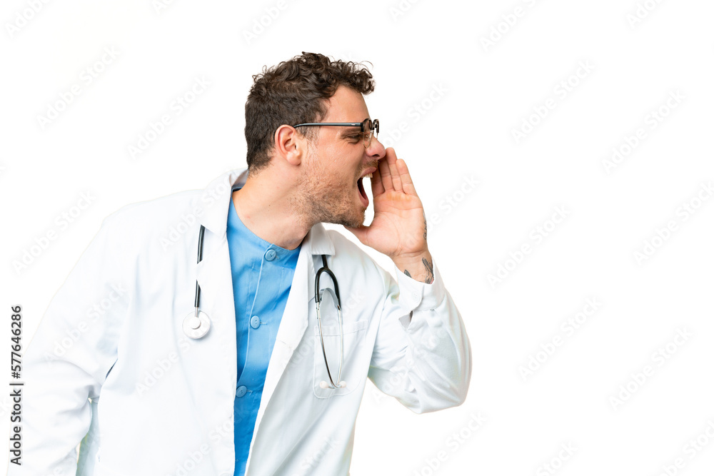 Brazilian doctor man over isolated chroma key background shouting with mouth wide open to the lateral Brazilian doctor man over isolated chroma key background shouting with mouth wide open to the lateral