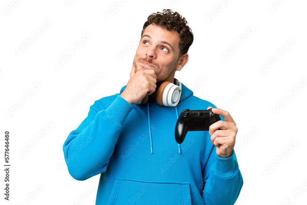 Brazilian man playing with a video game controller over isolated chroma key background and looking up Brazilian man playing with a video game controller over isolated chroma key background and looking up