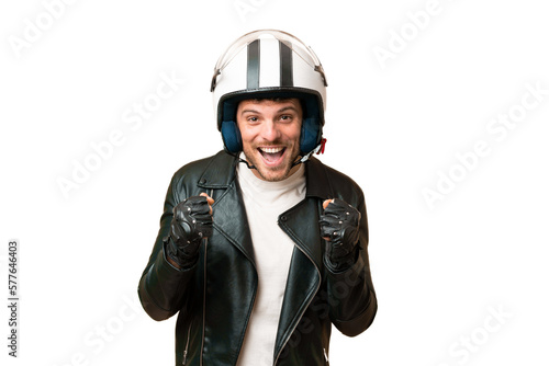 Brazilian man with a motorcycle helmet over isolated chroma key background celebrating a victory in winner position