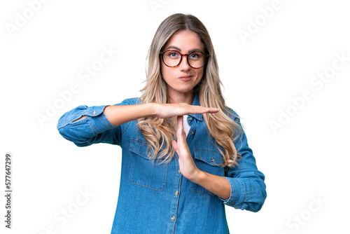 Young Uruguayan woman over isolated background making time out gesture