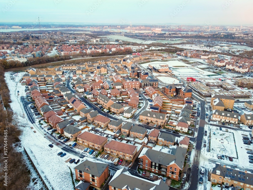 Aerial drone. Ebbsfleet garden city in Kent, covered in snow in December 2022. Aerial view of new developments and frozen lake alongside the A2 motorway.