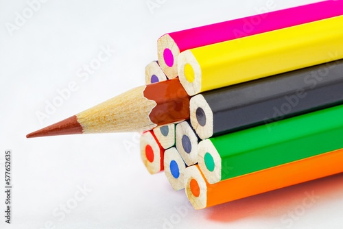 Colored pencils, ends are not sharpened, brown pencil sharpener, on white background, selective focus