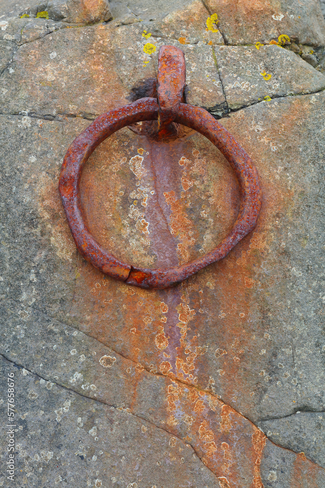 Close up image of a rusty old Mooring ring at Linisfarne, Holy Island, Northumberland, England, UK.