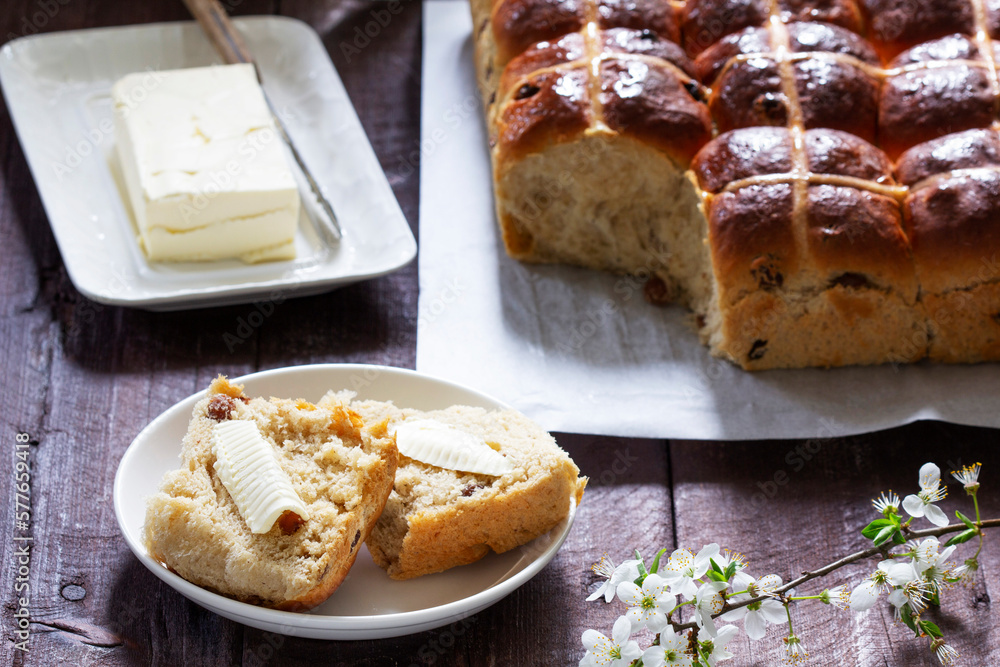 Cross buns served with butter, honey and tea. Easter breakfast.