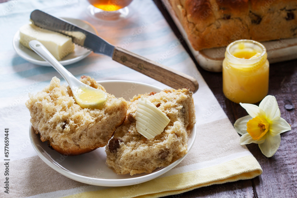 Cross buns served with butter, honey and tea. Easter breakfast.