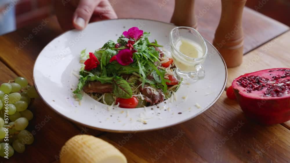 Duck salad served on a plate with half pomegranate and grapes on a wooden table. High-quality 4k footage Duck salad served on a plate with half pomegranate and grapes on a wooden table. High-quality 4k footage