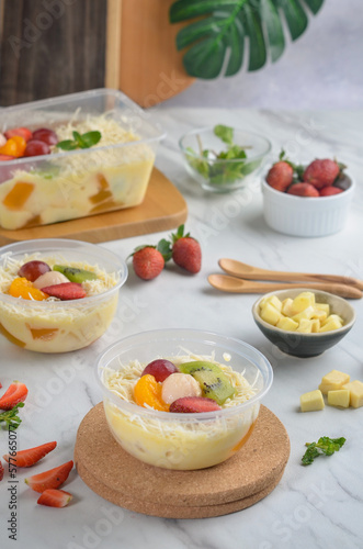 Fresh Fruit Salad made of strawberries, grapes, longan and apple and grated cheese
