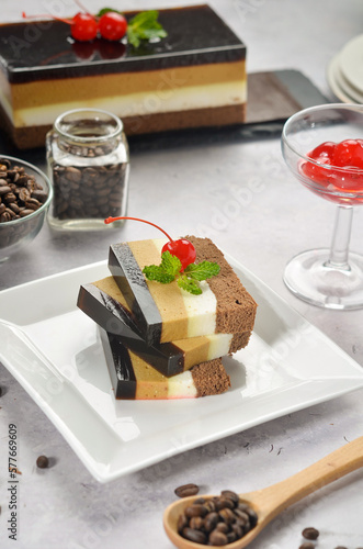 Layered dessert Trifles in a transparent glass. Sponge biscuit and three chocolate mousse layers. Chocolate souffle trifle cake in individual disposable transparent cups. White background photo