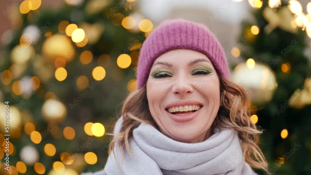 happy woman is smiling broadly, portrait on city streets in Christmas, blurred background happy woman is smiling broadly, portrait on city streets in Christmas, blurred background