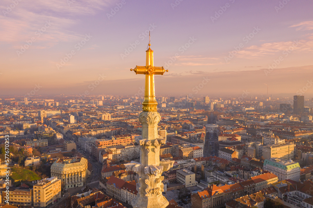 Golden Cross of Zagreb Cathedral in Croatia. It is on the Kaptol, is a Roman Catholic institution and the tallest building in Croatia. Sacral building in Gothic style. Cityscape in Background
